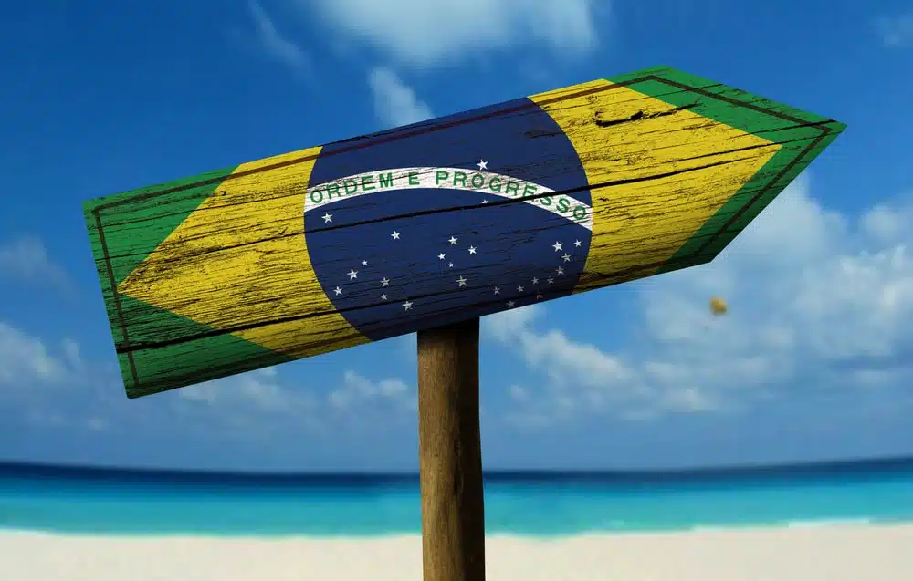 Brazil flag wooden sign with a beach on background Latin America