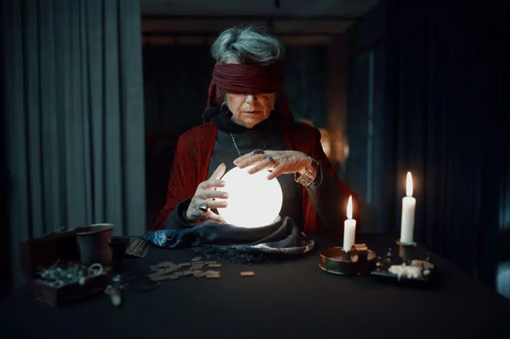 Blindfolded fortune teller using glowing crystal ball for future reading
