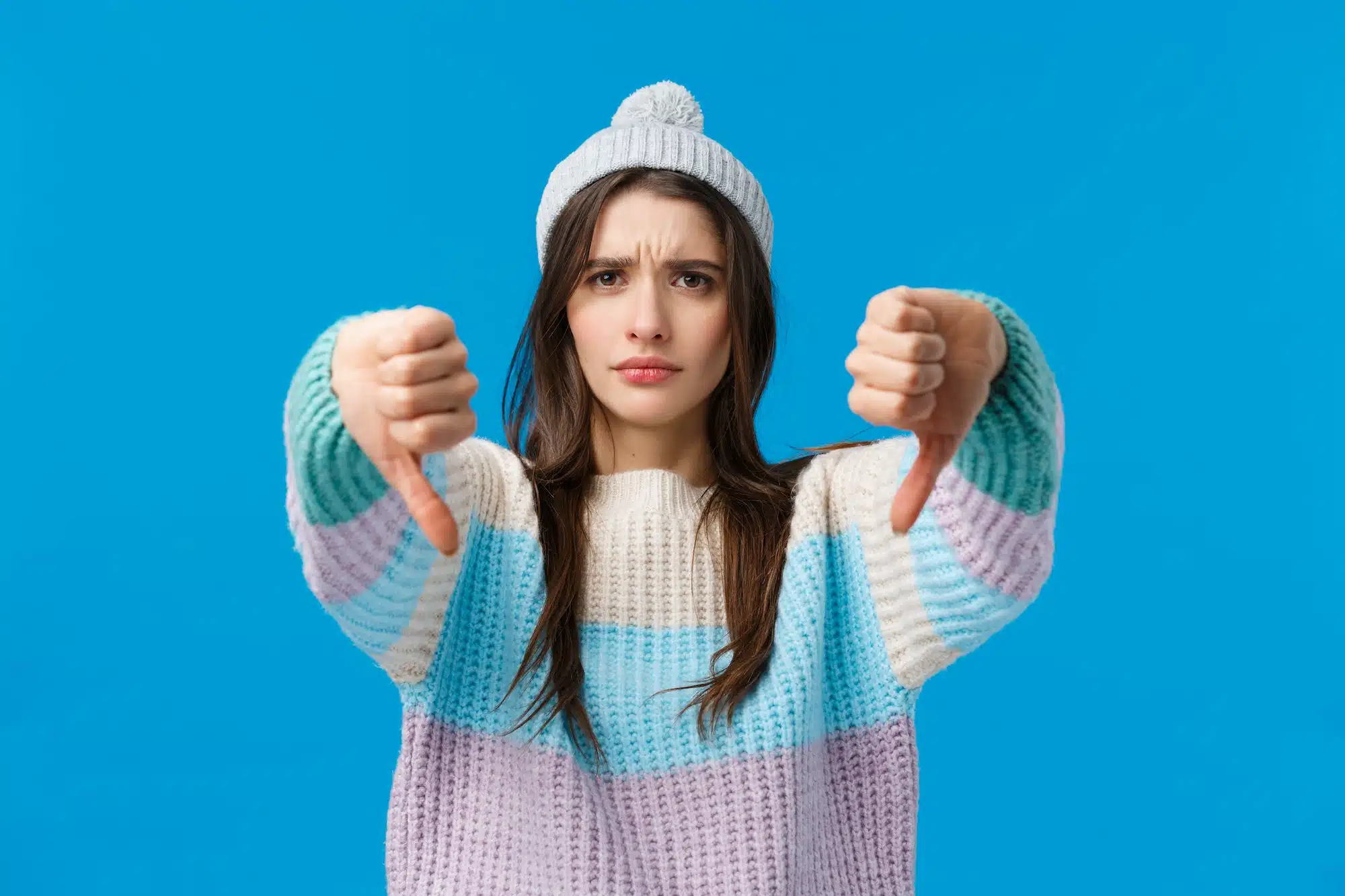 Bad idea, dont do it. Serious-looking upset and angry young woman in winter sweater, hat, looking