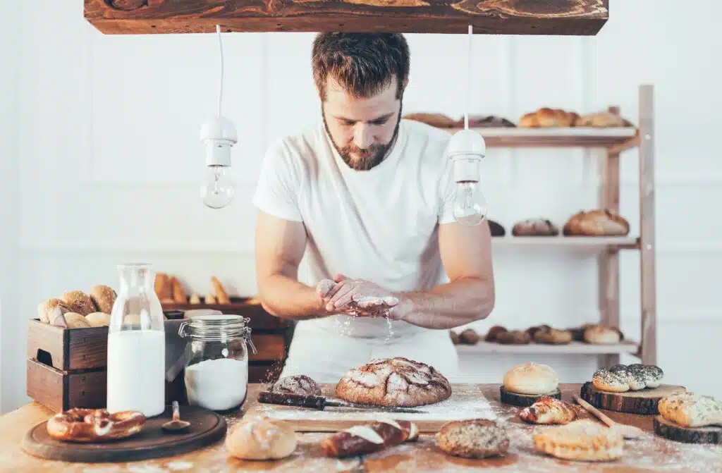 Baker with a variety of delicious freshly baked bread and pastry